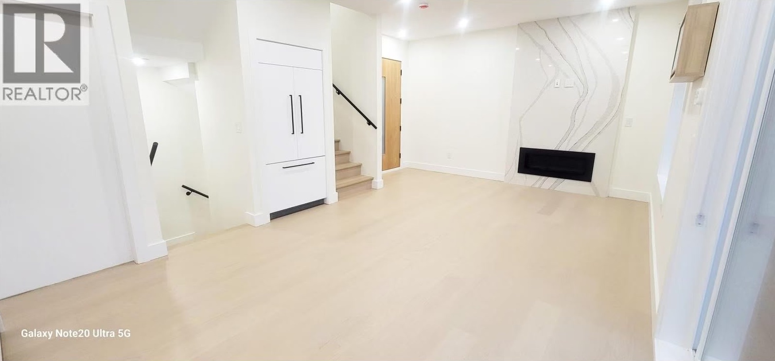 Living area with linear fireplace and slab feature wall