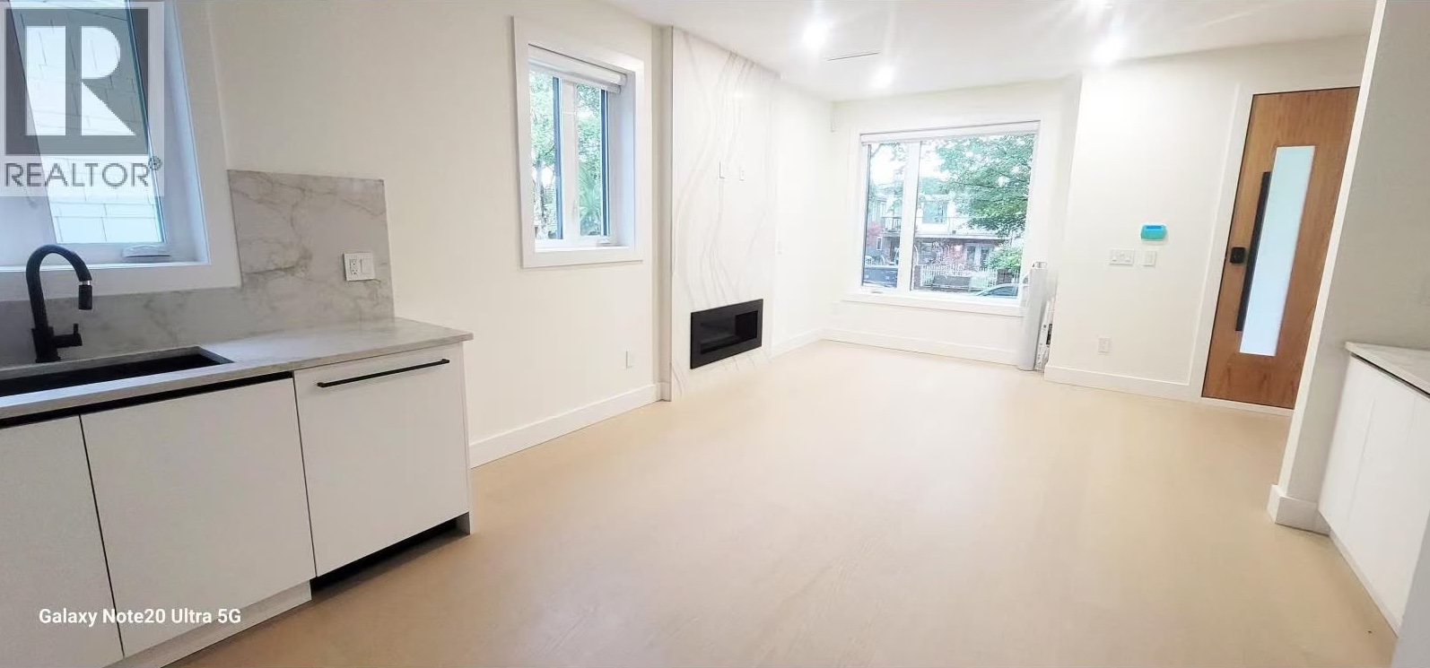 Open living area with fireplace, picture window and kitchen