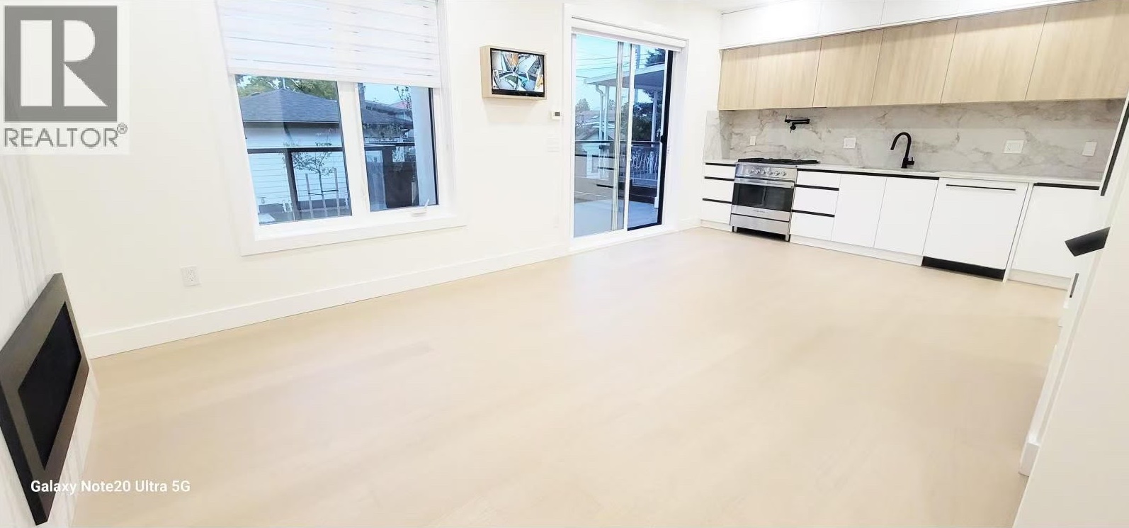 Great room with balcony door and full-height kitchen