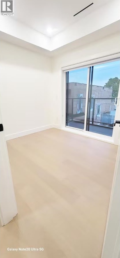 Bedroom with recessed ceiling detail and balcony access