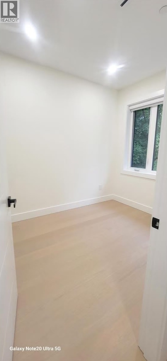 Bedroom with oak flooring and large window