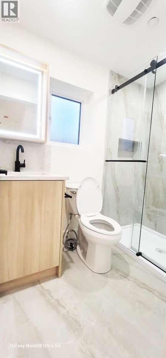 Ensuite with glass sliding shower door and oak vanity