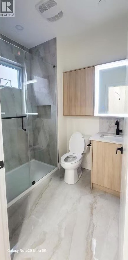Bathroom with frameless glass shower and lit mirror cabinet